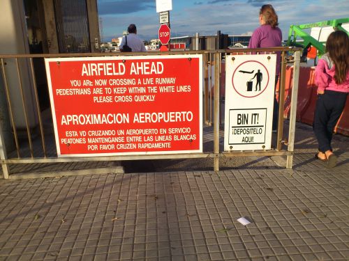 滑走路の前にある看板。この先は滑走路なので素早く渡るように促しています。