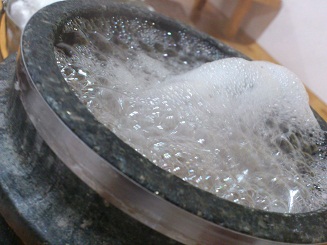 ２．熱々の石鍋に水が注がれ、吹きこぼれそうです
