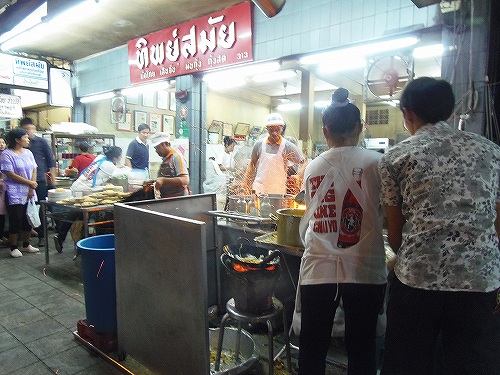 「外キッチン」で早業を披露するおばさん（手前の白い女性）