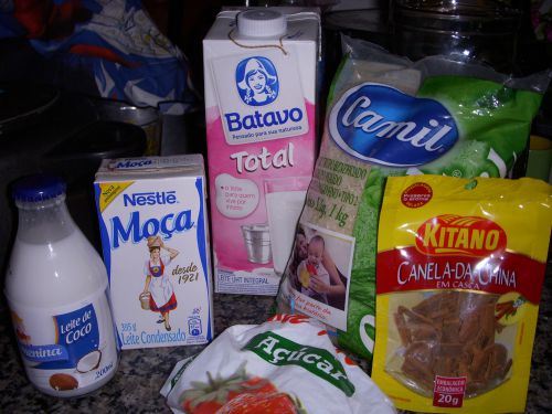 「アロース・ドーセ」の材料。左から、ココナッツミルク、コンデンスミルク、牛乳、米（陸稲）、シナモンの断片、手前の袋は砂糖。「カンジッカ・ドーセ」もほぼ同じ材料で、これらにクローヴ（丁子）も加わる。好みでココナッツを加えてもよい