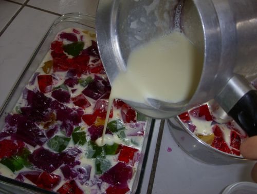 切り分けたゼリーを型に入れ、ゼラチンを加えたクリームを流しいれているところ