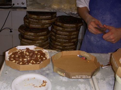 溶けたチョコレートの上にチョコレート菓子を刻んでトッピングしている様子