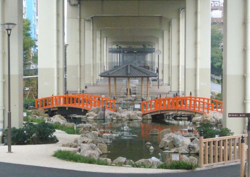 高架下に橋がかかっています。池もあります。