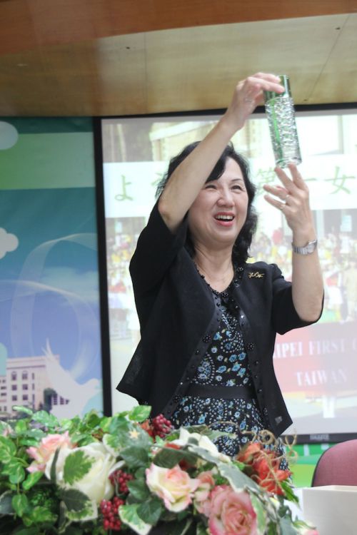 記念品を手に取り、笑顔を見せる北一女の張碧娟（ジャン・ビージュェン）校長