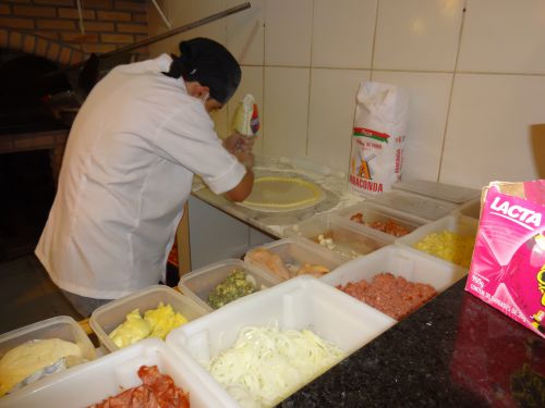 ピザ生地の縁にクリーム状のカトゥピリを絞り出しているところ