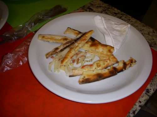 通常のピザ生地の縁を、捨てるためにお皿に寄せ集めた様子