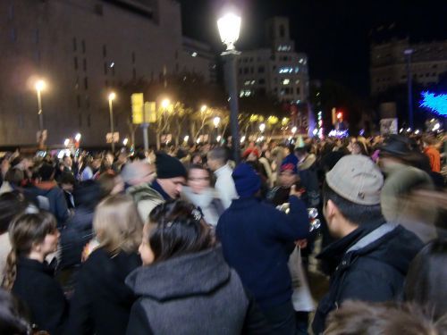 飲み物をいくつか持って、人混みの間で売っている青い帽子の男