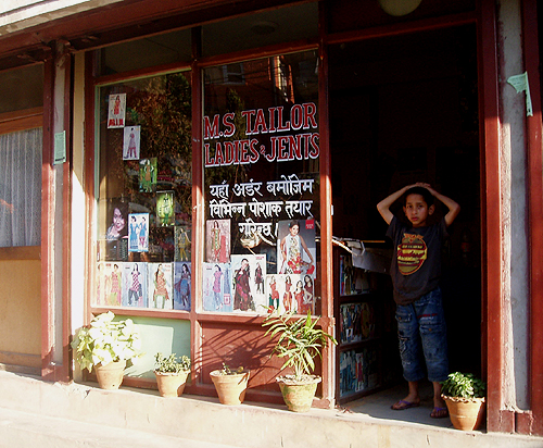 住宅街の仕立て屋。店内にお客の生地や出来上がりの服が掛けてあります。