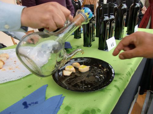 オリーブ油をパンにつけ、油の味を確認してから購入するお客さん