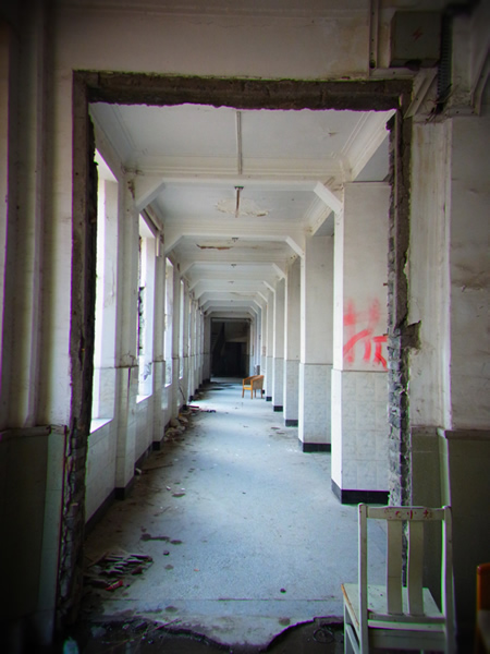 右の柱に書かれている赤字の「拆（チャイ）」の文字は、 この建物を取り壊すという意味