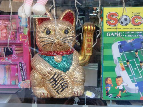 おもちゃ屋さんの店頭で、手招いている大きな「まねき猫」