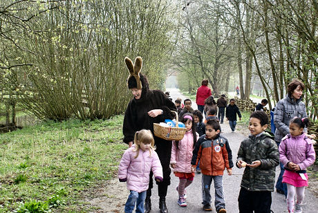 ウサギの格好をした教師と一緒に卵を探す子どもたち。