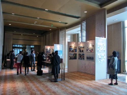 会場の展示を見る人々と、キャンドルへのメッセージを書く人々