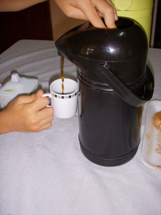 ブラジルの家庭で保温ポットから注がれるコーヒー