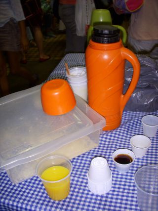 仲間内で使い捨てコップに保温ポットから注いで飲むコーヒー