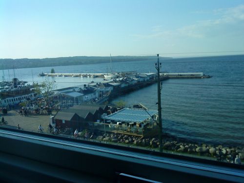 ホテルの部屋の窓から眺めた風景、この周辺には湖に面するレストランが立ち並んでいます。天気の良いときには、多くの人々がテラス席に座っています。