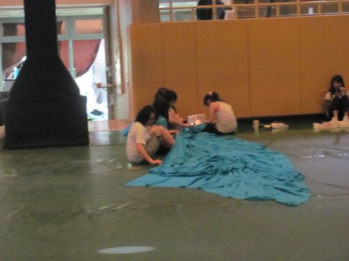 会場の設置作業に入り、ツメの縫製作業をしています