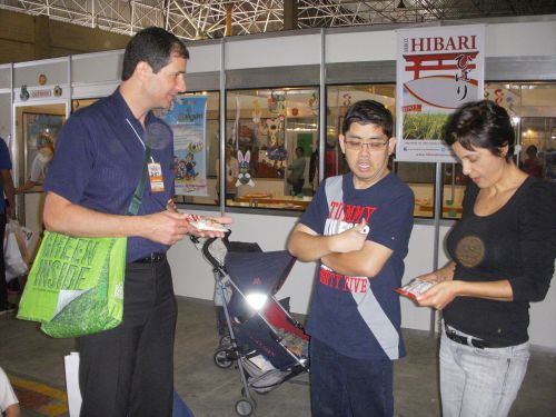 第16回日本祭りの子供広場のおにぎり作りコーナー前で水稲ブランド『ひばり』を宣伝するブラジル人男性