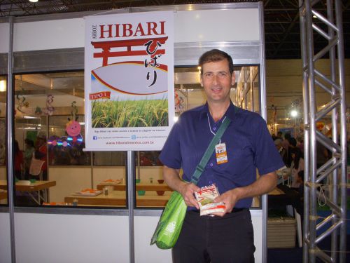 第16回日本祭りの子供広場のおにぎり作りコーナー前で水稲ブランド『ひばり』を宣伝するブラジル人男性