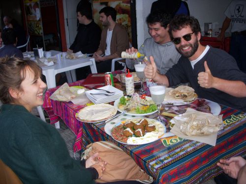 隣接するペルー料理店とアラブ料理店からメニューを注文して昼食を楽しむブラジル人。セビーチェ（中央）とピスコサワー（グラス）、アラブ料理（下）がテーブルに並ぶ