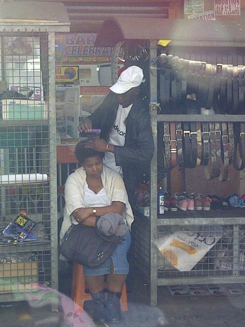 道端で髪を整えてもらう黒人女性。ヨハネスブルグ市内（黒人居住区）で見かけました。