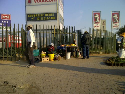 道端の露店。行き交う人が、ちょっとした物（主に食べ物）を買います。