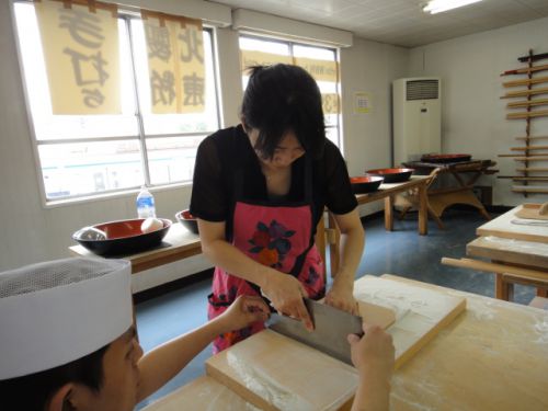 真剣に麺を切る体験者の方
