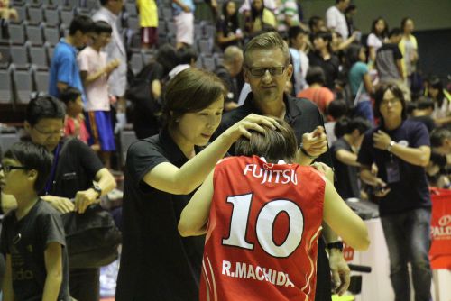 7アシストの活躍を見せた町田瑠唯（まちだ　るい）の頭をなでる薮内夏美ヘッドコーチ　（後ろはBT・テーブス　コーチ）