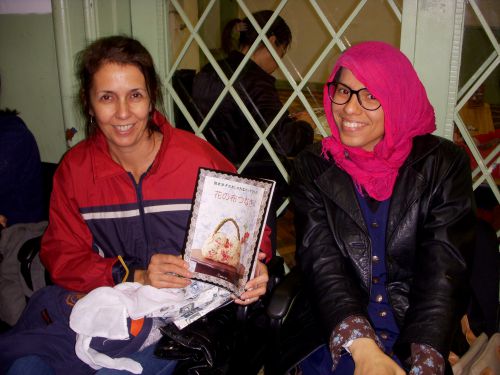 日本で出版された日本語の手芸の本を手に持つ、手芸を趣味とするブラジルの女性