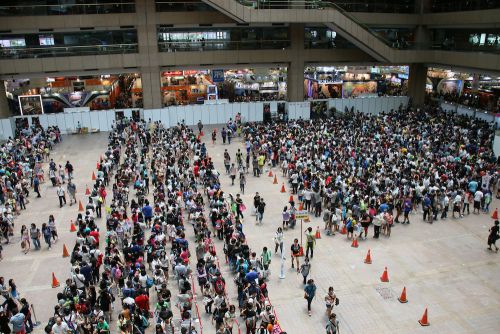 人気ブースの販売コーナーに入るために並ぶ入場者たち