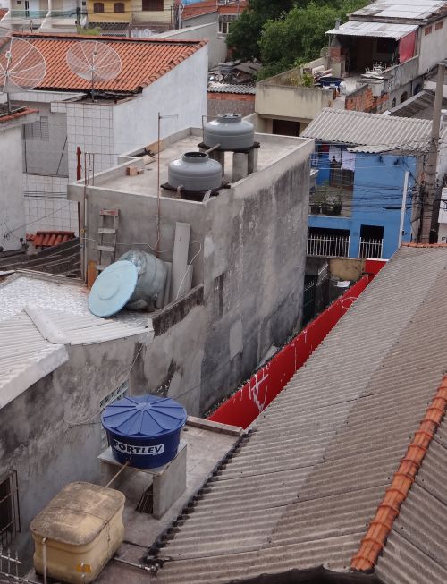 小雨を利用して、屋上の貯水タンクのふたを開けて水を貯めている家屋