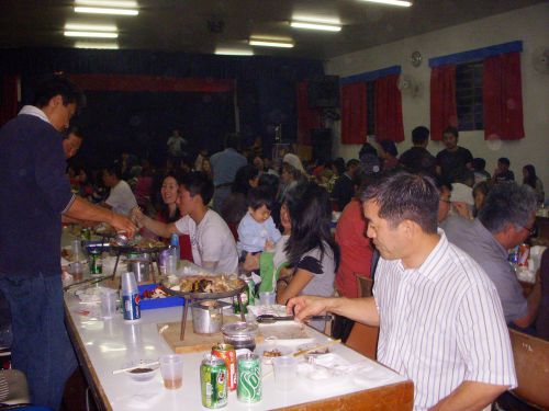 イタペチ地区の日本人会の親睦会でジンギスカンを食べる人々