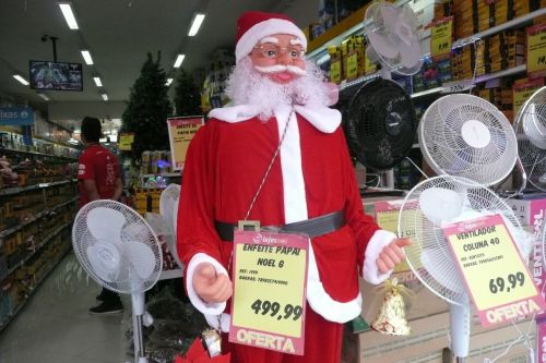 扇風機と並んで販売される歌って踊ってお辞儀する人間と等身大のサンタクロース