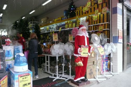 扇風機と並んで販売される歌って踊ってお辞儀する人間と等身大のサンタクロース