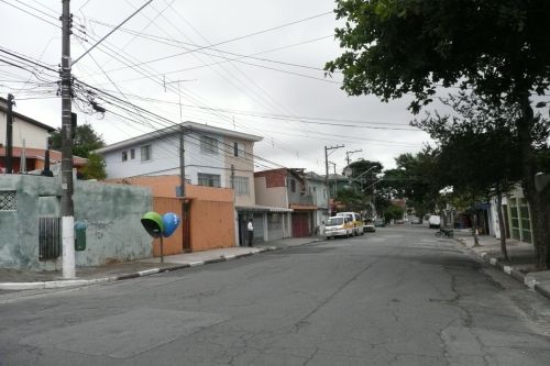 通りの片側の電柱の電線から向かいに電線を引いている風景