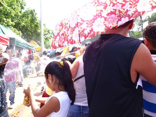 ボリビアコミュニティーのカーニヴァルで通りすがりの者同士、泡スプレーをかけあう様子