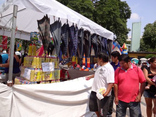 ボリビアコミュニティーのカーニヴァルで、泡スプレーと傘を販売する屋台