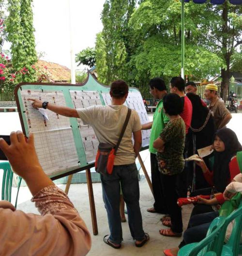 投票所前で候補者名簿を見ながら真剣に議論しています