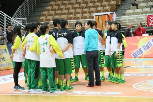 試合前、ウォームアップ中の選手に声をかける駱燕萍HC（水色のフーディーとジーンズ姿））