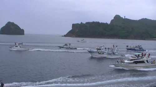 おがさわら丸を追いかける、多くの漁船や観光船。この中には帰る日の午前中にお世話になった観光船と、そのスタッフの姿もありました。