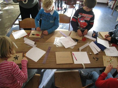 中学生と一緒に工作に臨む小学校高学年生たち。