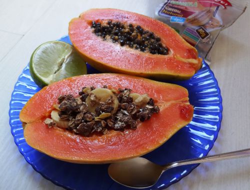 シリアル類を盛ったパパイヤ（手前）種が入ったままのパパイヤ（後方）