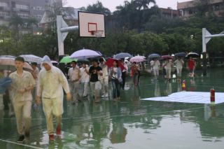 卒業式が行なわれる活動中心へ移動する卒業生たち