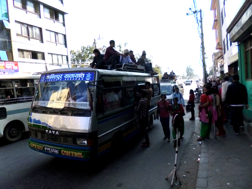 満員バスの屋根に乗車する客
