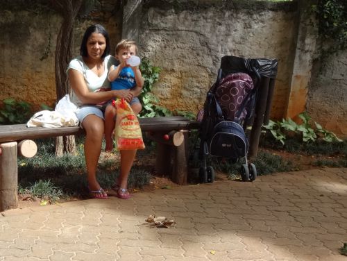 ブラジルの公園でくつろぐベビーシッターの女性と世話する子ども