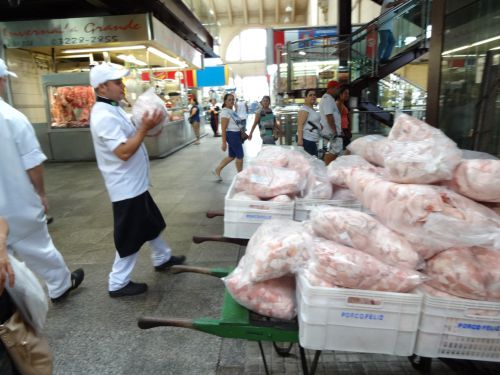 市立市場の豚肉売り場で、豚の皮だけが大量にまとめて運ばれる風景
