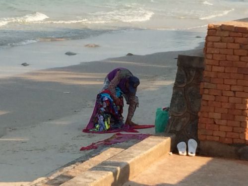 大量の水着をまとめて店じまい中のおじさん