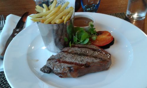 イギリスのマンチェスターにて、ステーキのソースは別注文する必要があり、別皿（大皿の中央上の黒胡椒ソース）です。