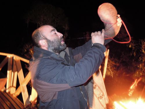 ボタと呼ばれるヤギの皮で出来た袋を使ってワインを飲む人