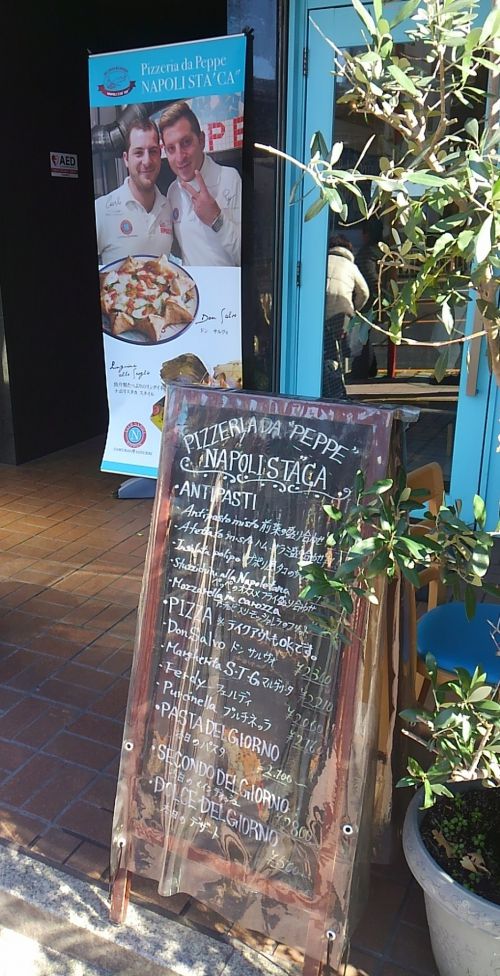 お店の外観。ピザ職人さんの写真が目印。